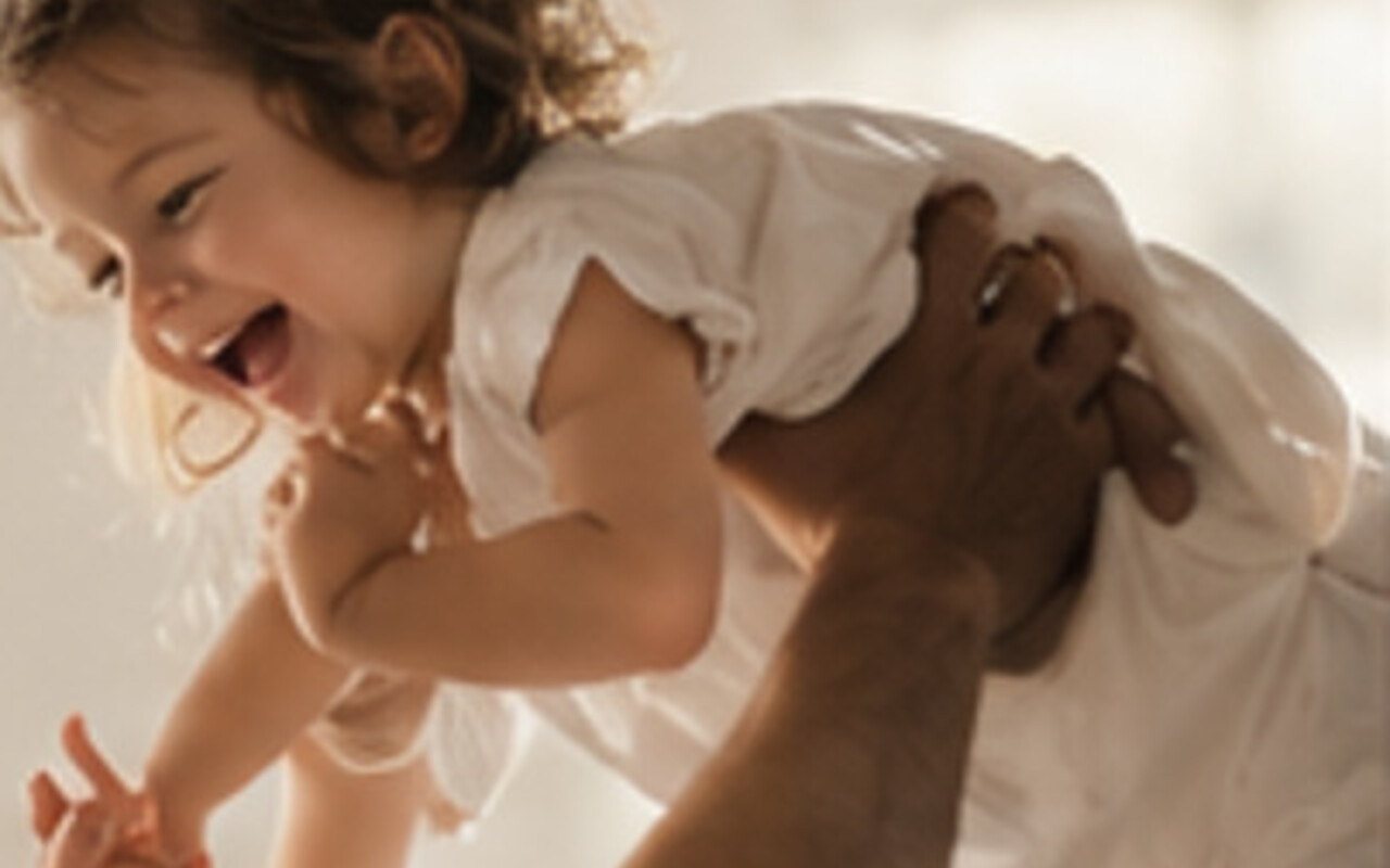 A parent lifting a laughing child